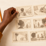 Mains disposant des cartes de storyboard sur une table de travail, pour évoquer la formation audiovisuelle.
